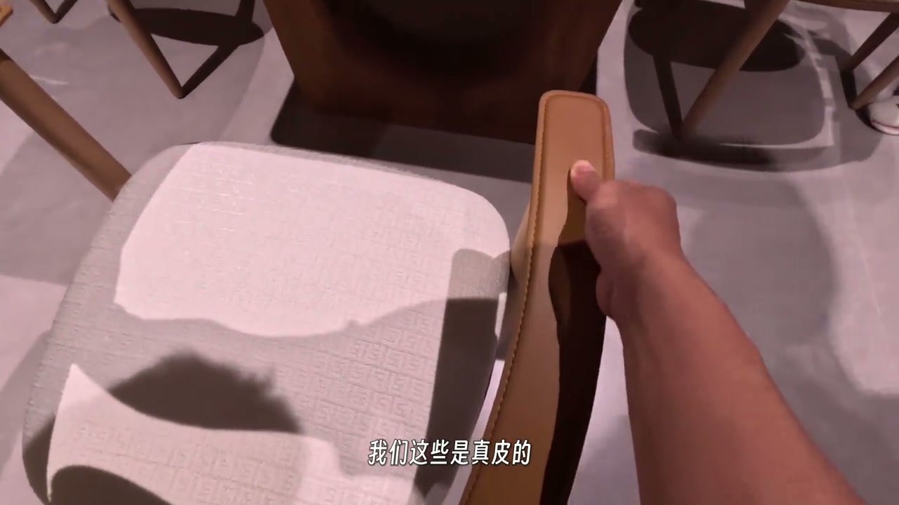 Hand checking the upholstery of a dining chair in the showroom