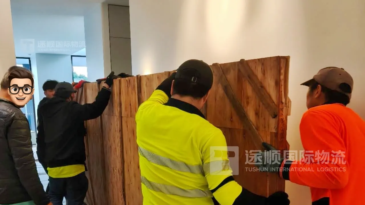 Local delivery crew in hi-vis carrying a cabinet into a house in Australia