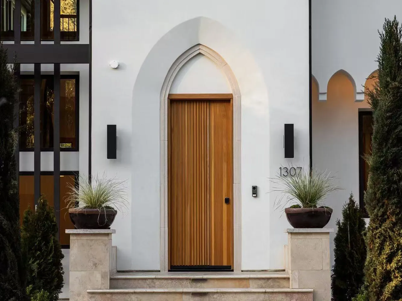 Arched entry with a timber door, Palo Alto model home