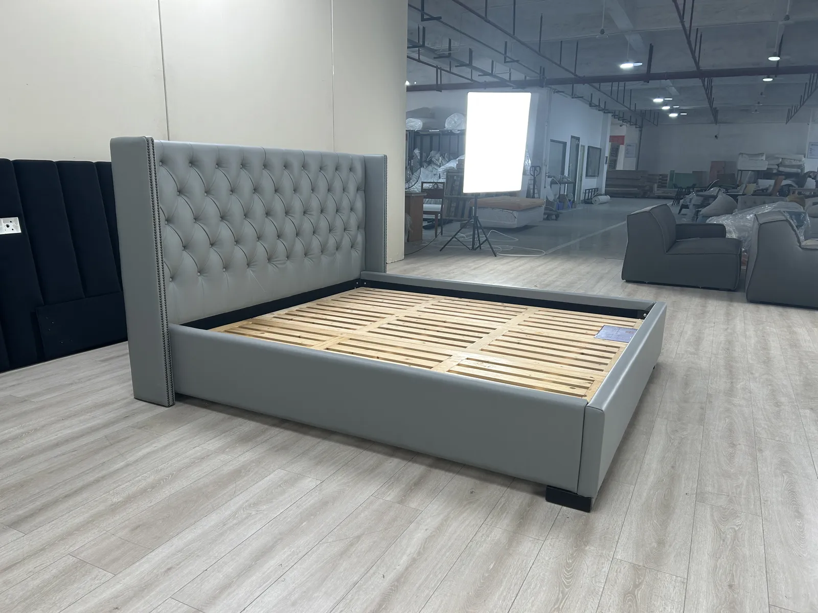 Tufted bed frame assembled with slats visible for inspection