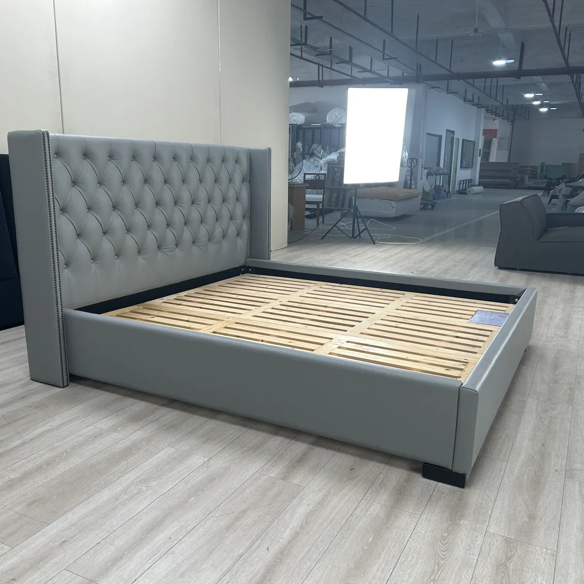 Tufted bed frame assembled with slats visible for inspection