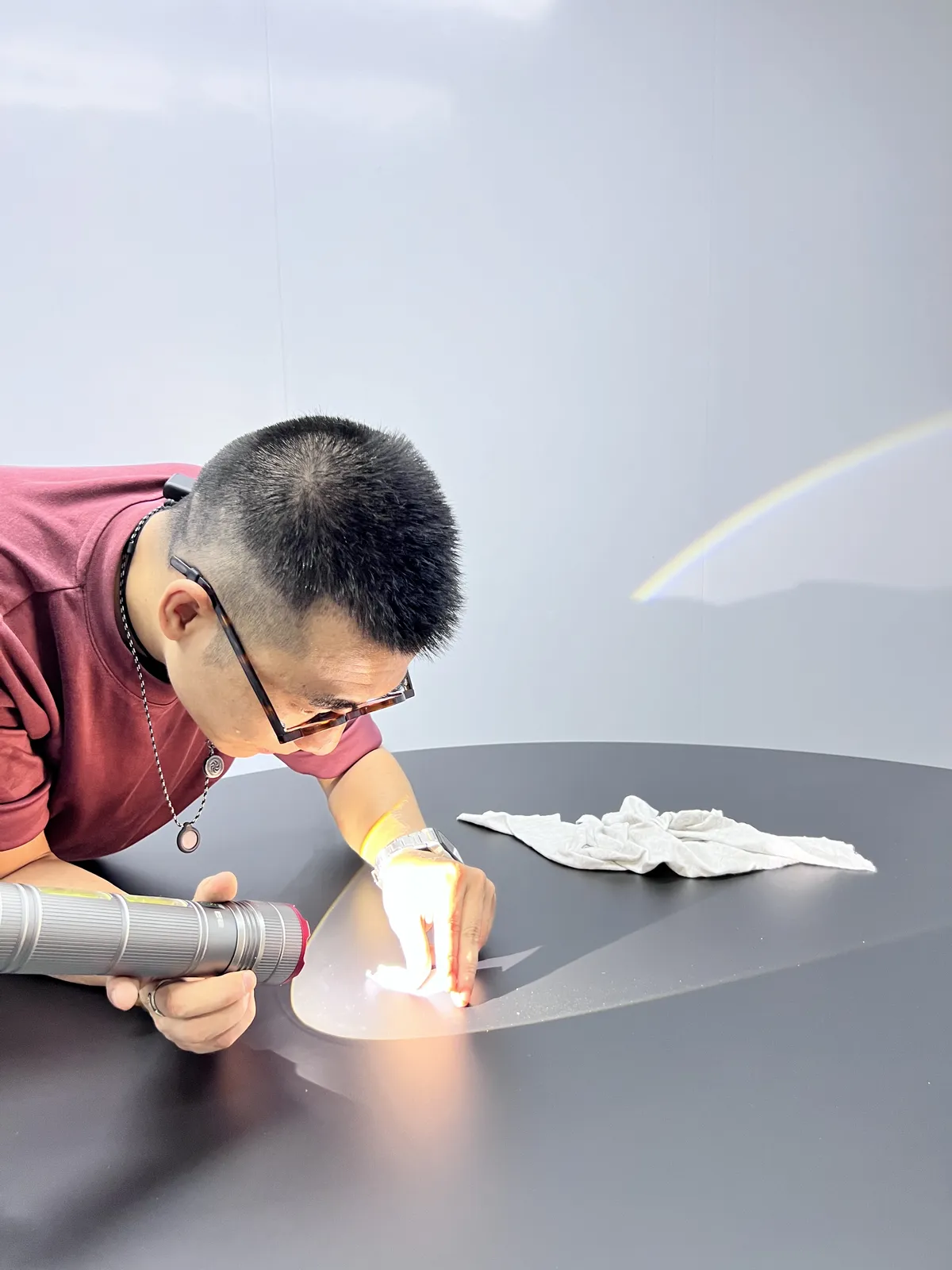 Inspector checking a lacquered surface under a hand light