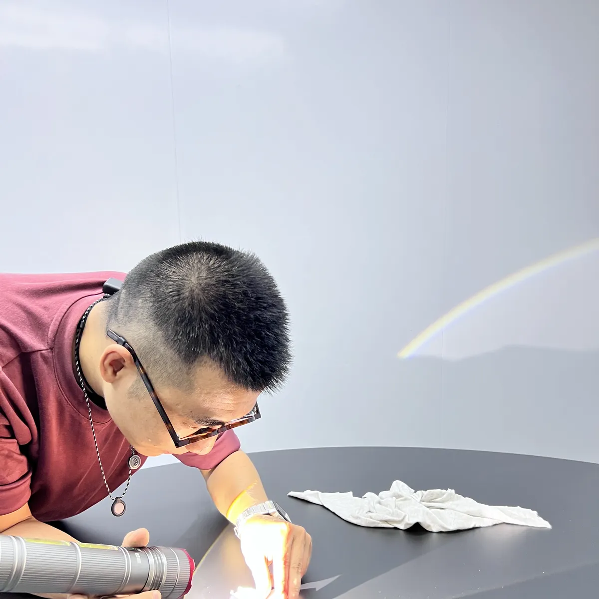 Inspector checking a lacquered surface under a hand light