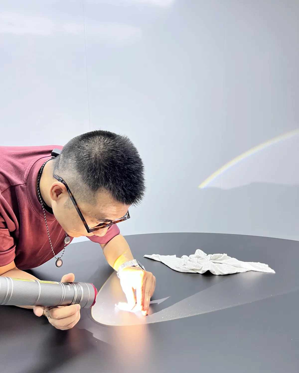 Inspector checking a lacquered surface under a hand light