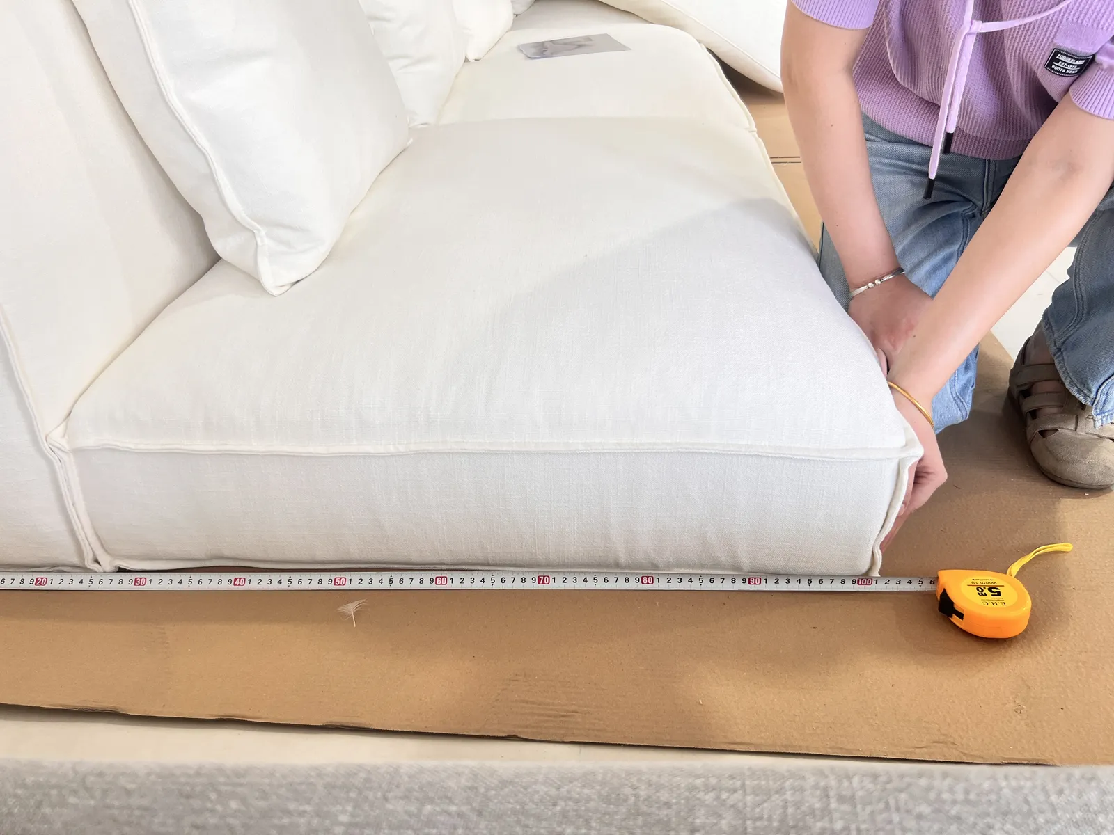 Tape measure laid along a sofa seat during inspection