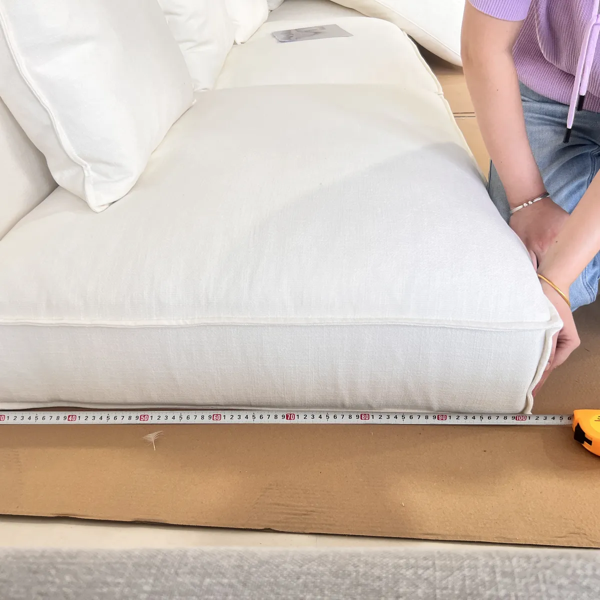 Tape measure laid along a sofa seat during inspection