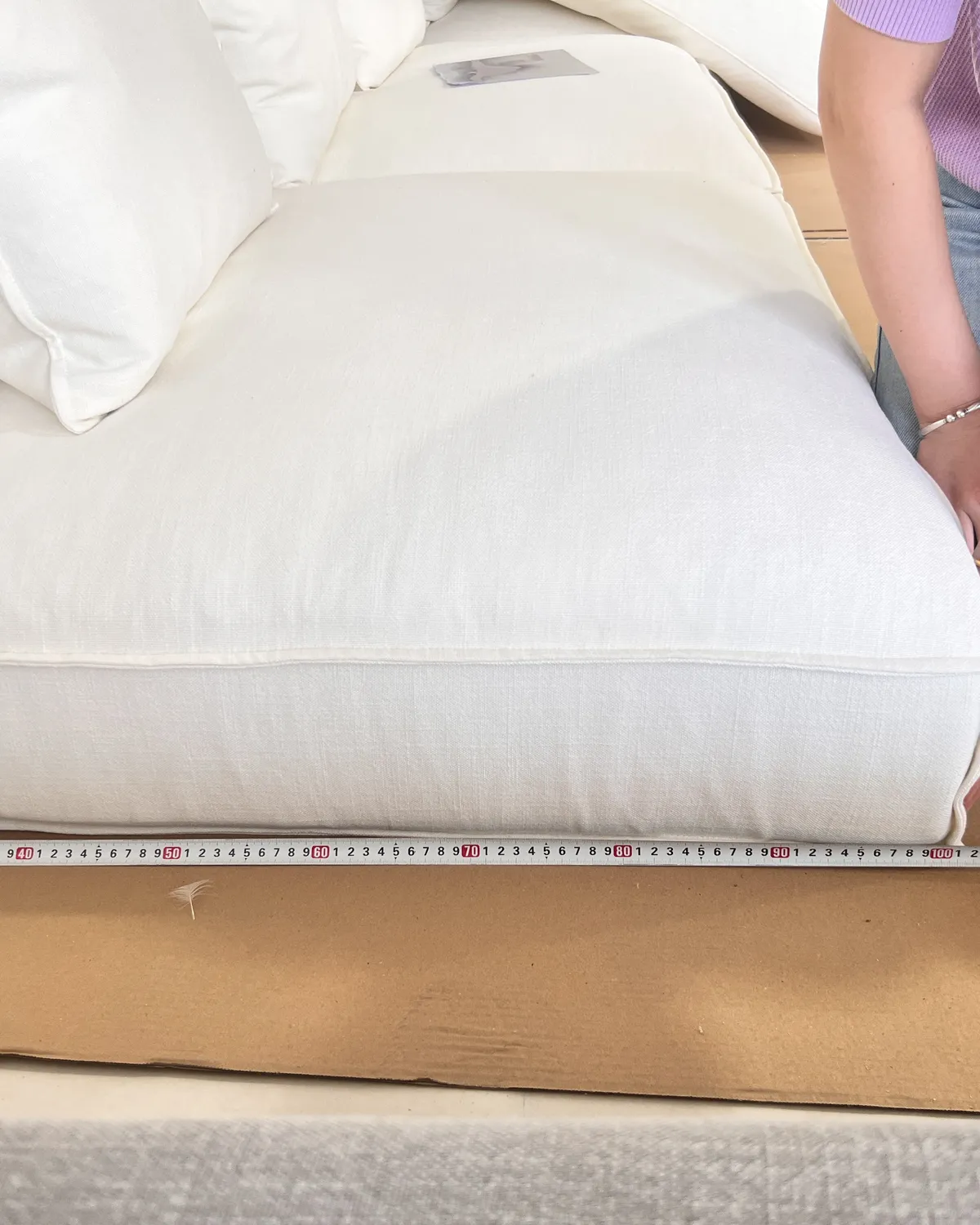 Tape measure laid along a sofa seat during inspection