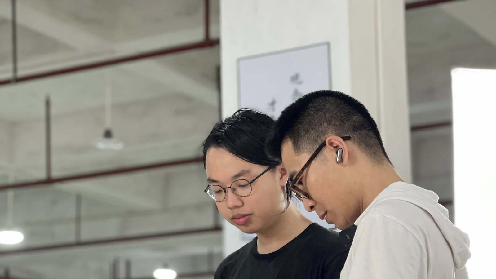 Two inspectors checking a piece against the specification on a tablet