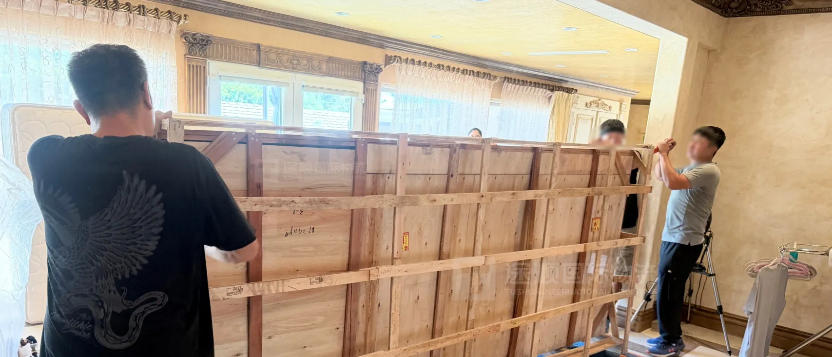 Braced timber crates lined up inside the house before unpacking